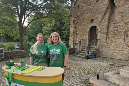 Zwei Personen stehen hinter einem Aufsteller und machen Werbung für die WOGES