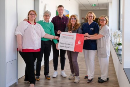 Mehrere Personen halten einen Spendencheck in der Hand